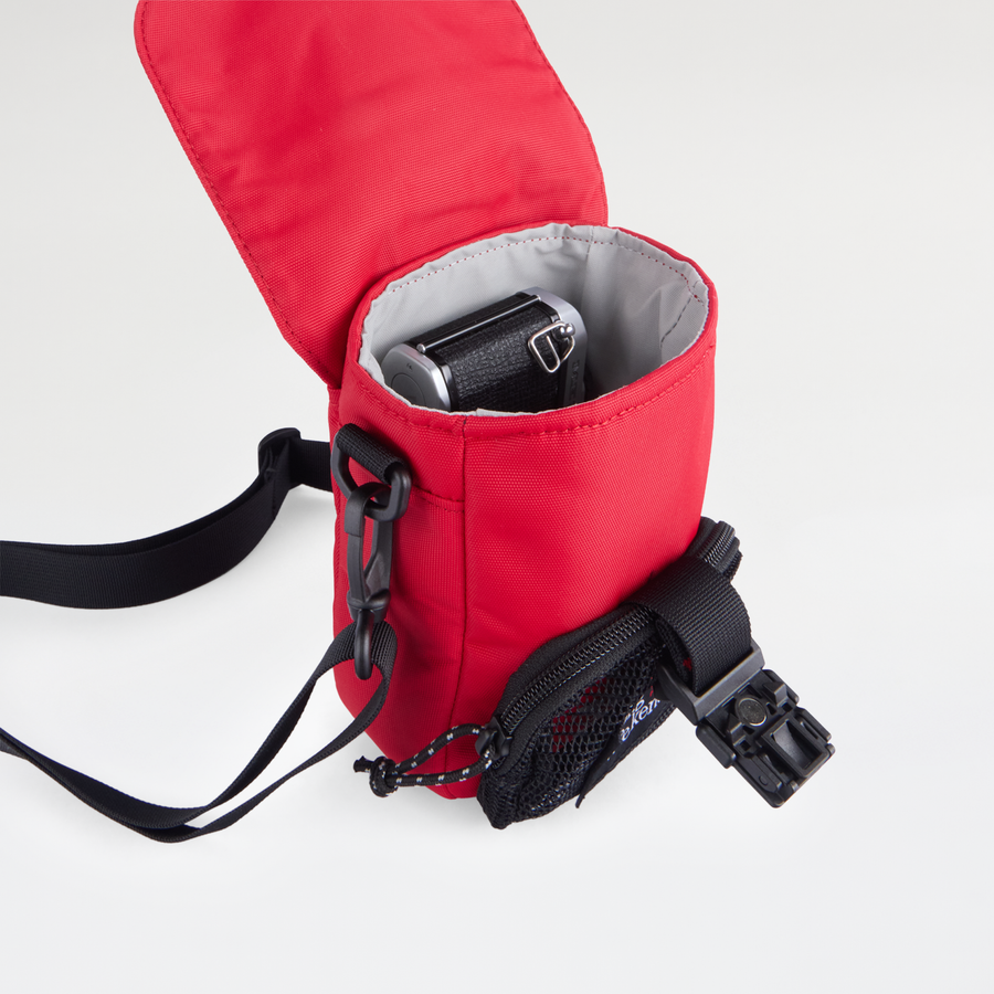 Long Weekend Crossbody Bag in Red, open with a camera inside