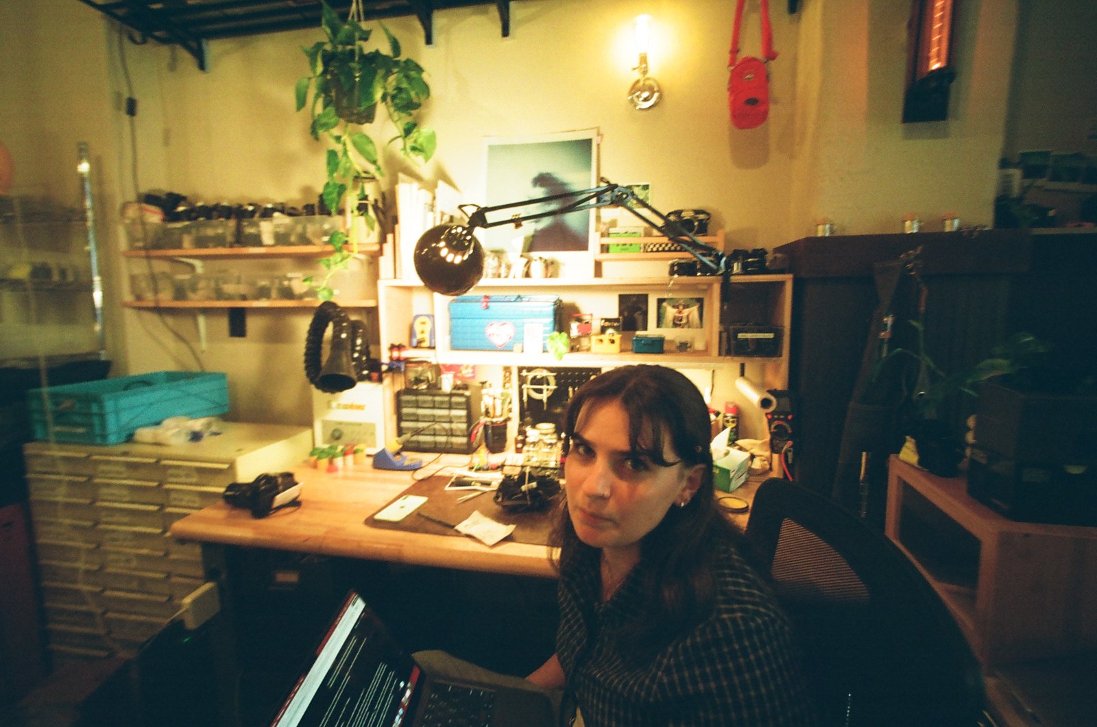 Person at a cluttered desk at night, shot on 35mm